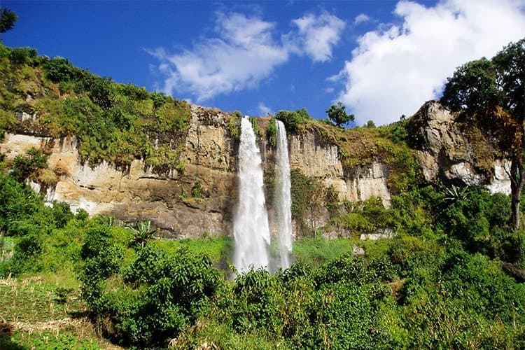 Sipi Falls dropping over a green cliff in eastern Uganda
