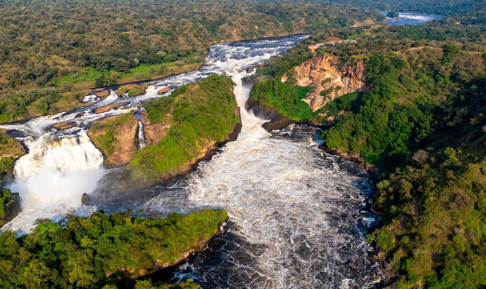 The Nile plunging between rocky cliffs and wooded banks at Murchison Falls.