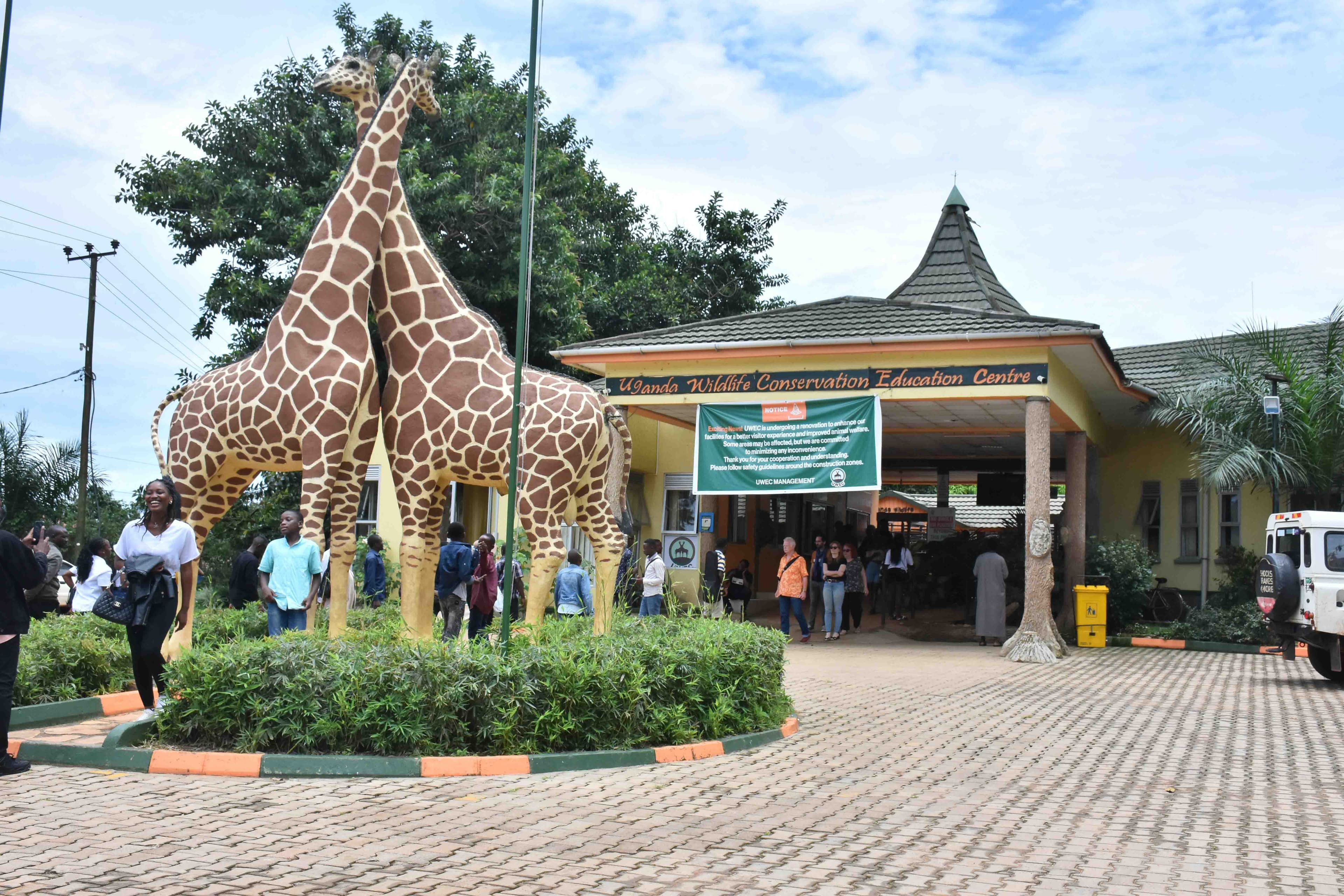 Giraffe sculptures and the entrance sign at Uganda Wildlife Conservation Education Centre in Entebbe.