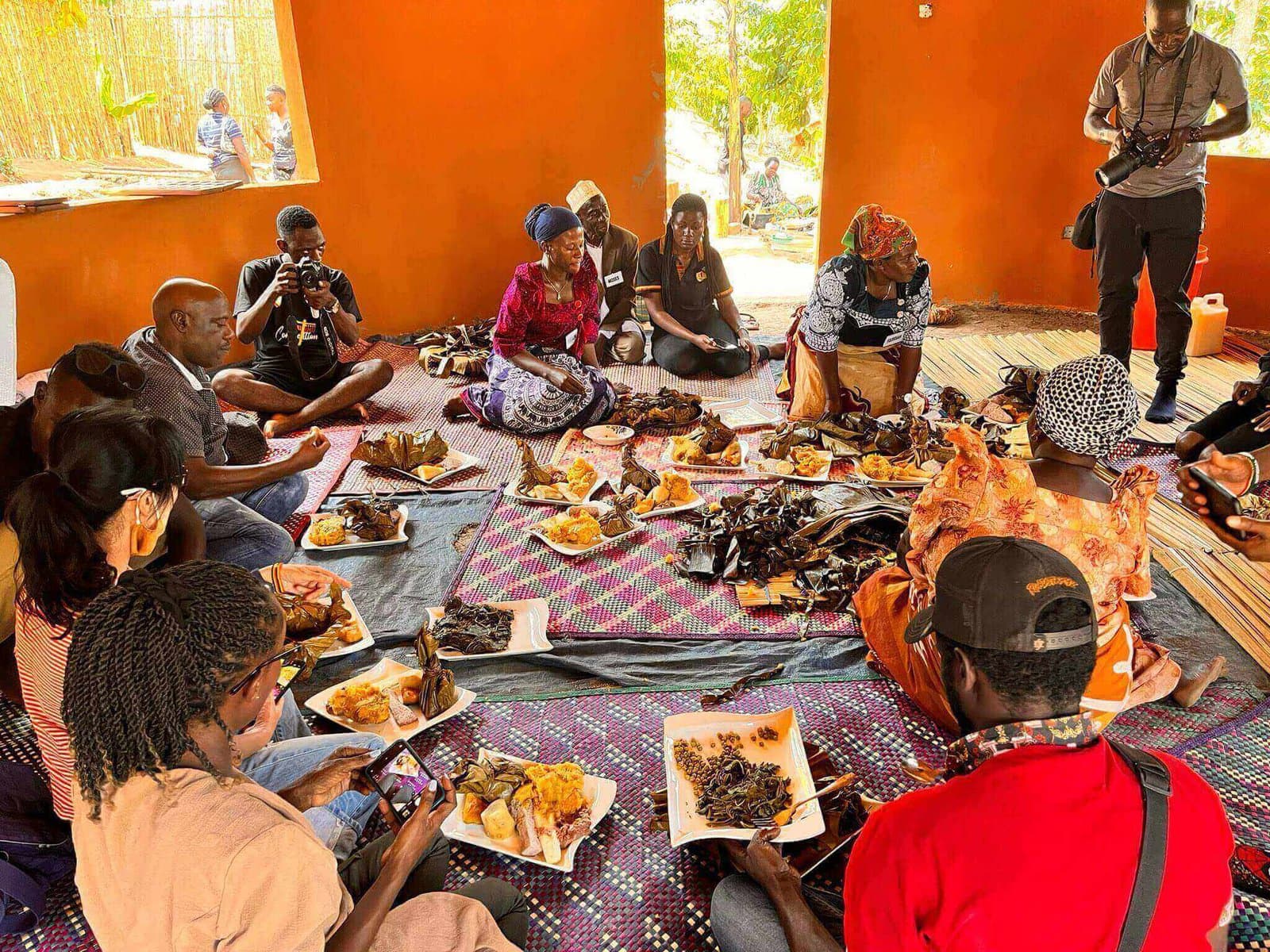 A group sharing a spread of traditional Ugandan dishes