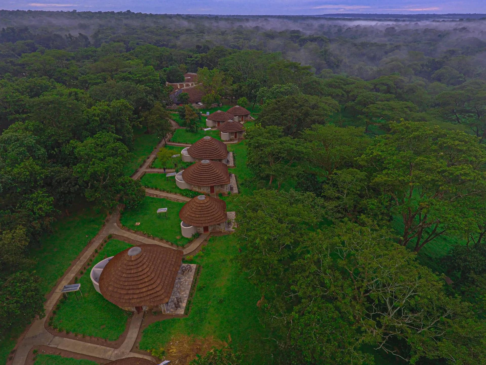 An aerial view of cottages among trees at Sambiya River Lodge.